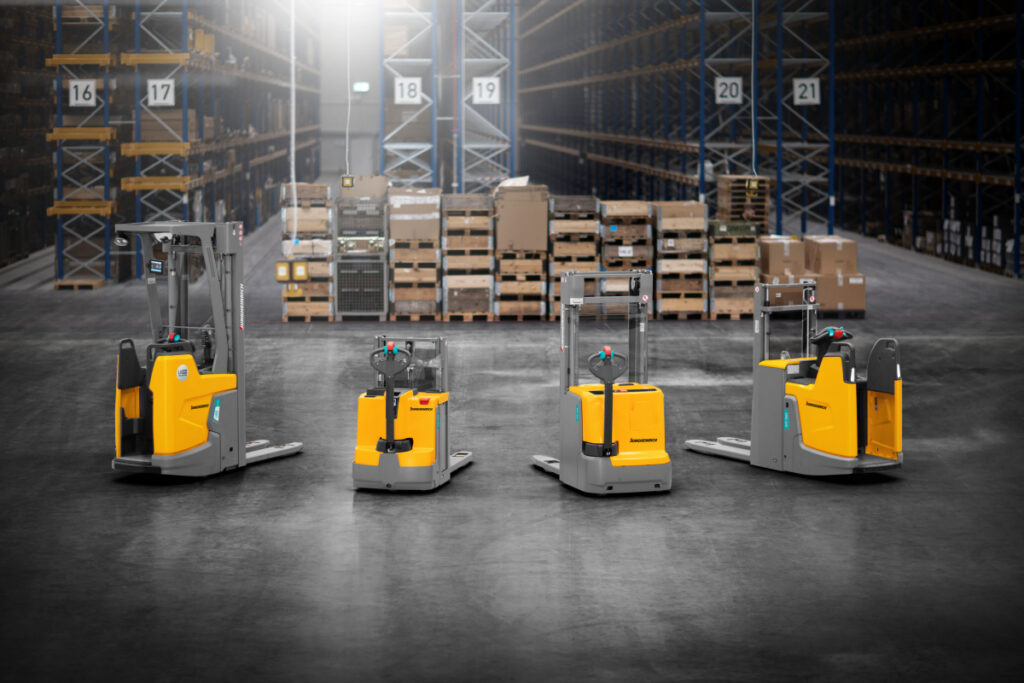 Żółte wózki widłowe usatwione w rzędzie, w magazynie