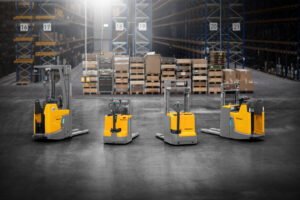 Żółte wózki widłowe usatwione w rzędzie, w magazynie