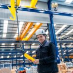 Fachowiec steruje suwnicą podczas relokacji zakładu produkcyjnego